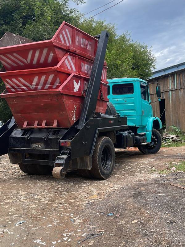 Caminhão com três caçambas vermelhas empilhadas