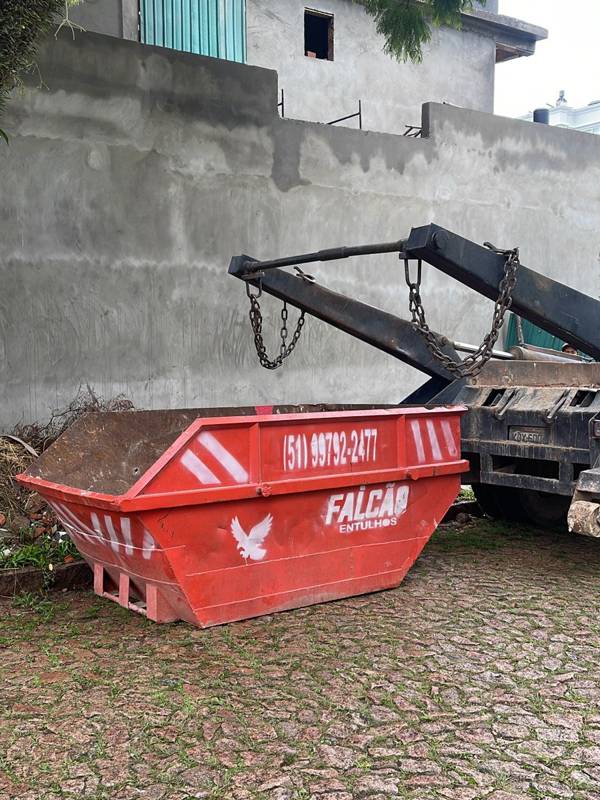 Caçamba vermelha entregue em frente a uma obra